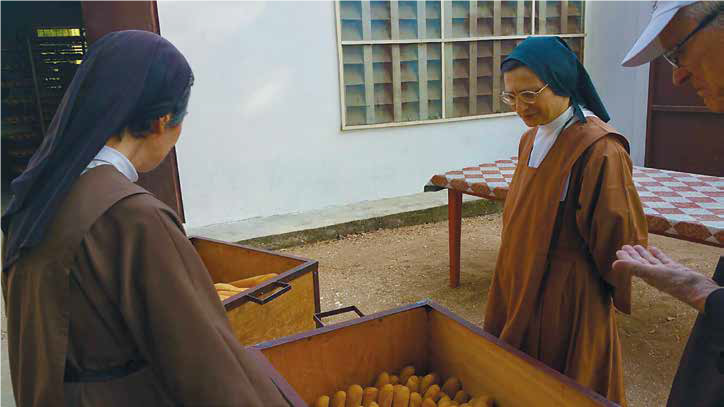 Due monache che controllano il pane appena sfornato